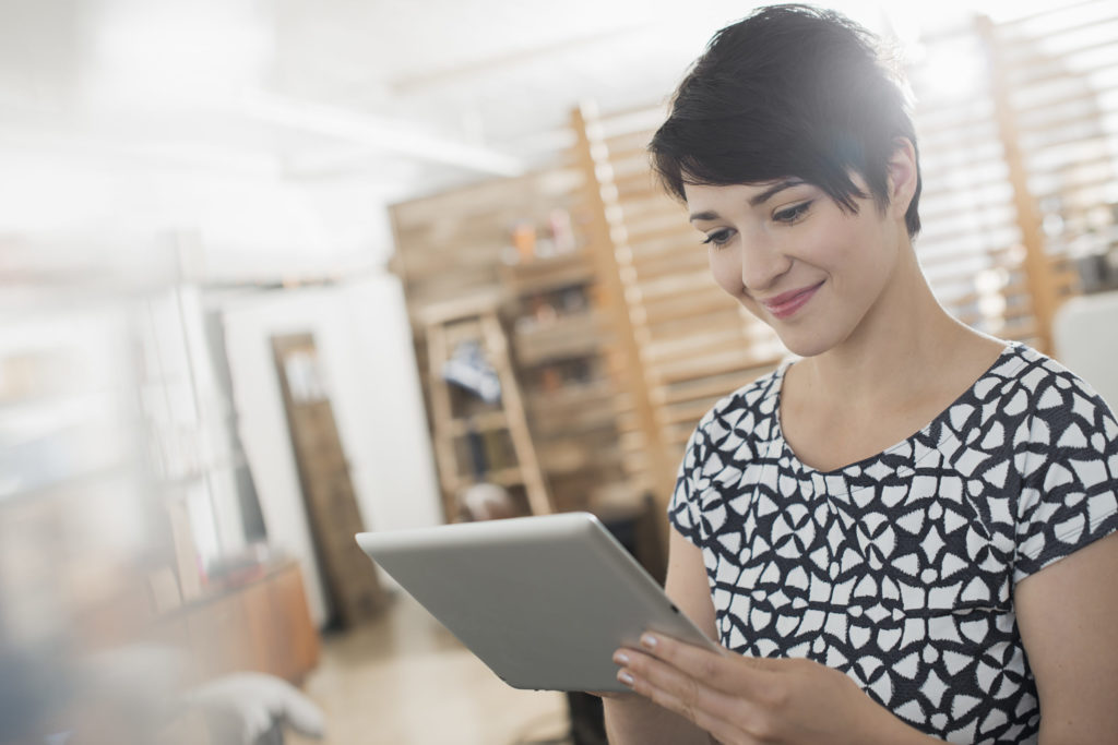 A woman at home using a digital tablet.